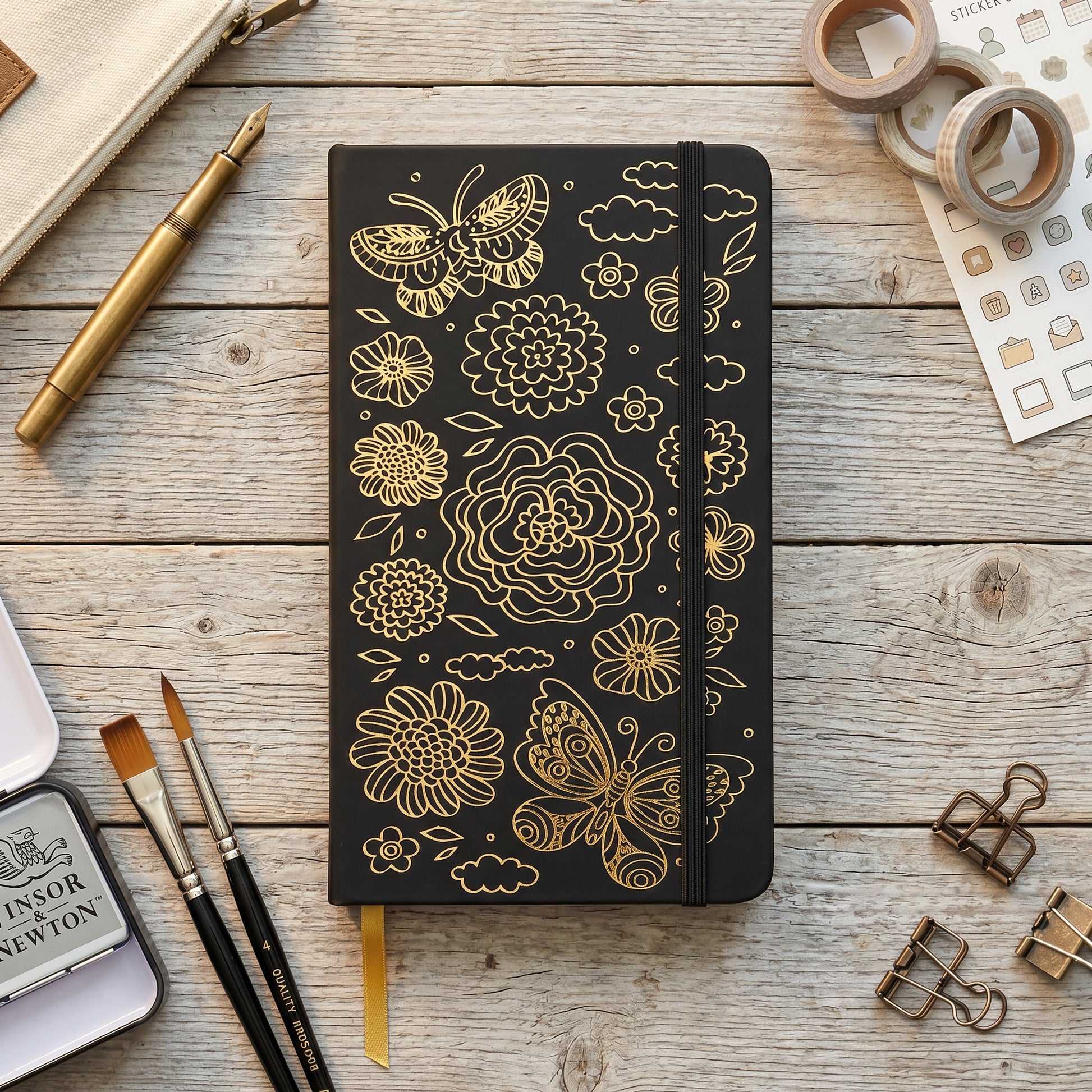 Close-up of gold butterfly and floral design on black faux PU leather notebook cover