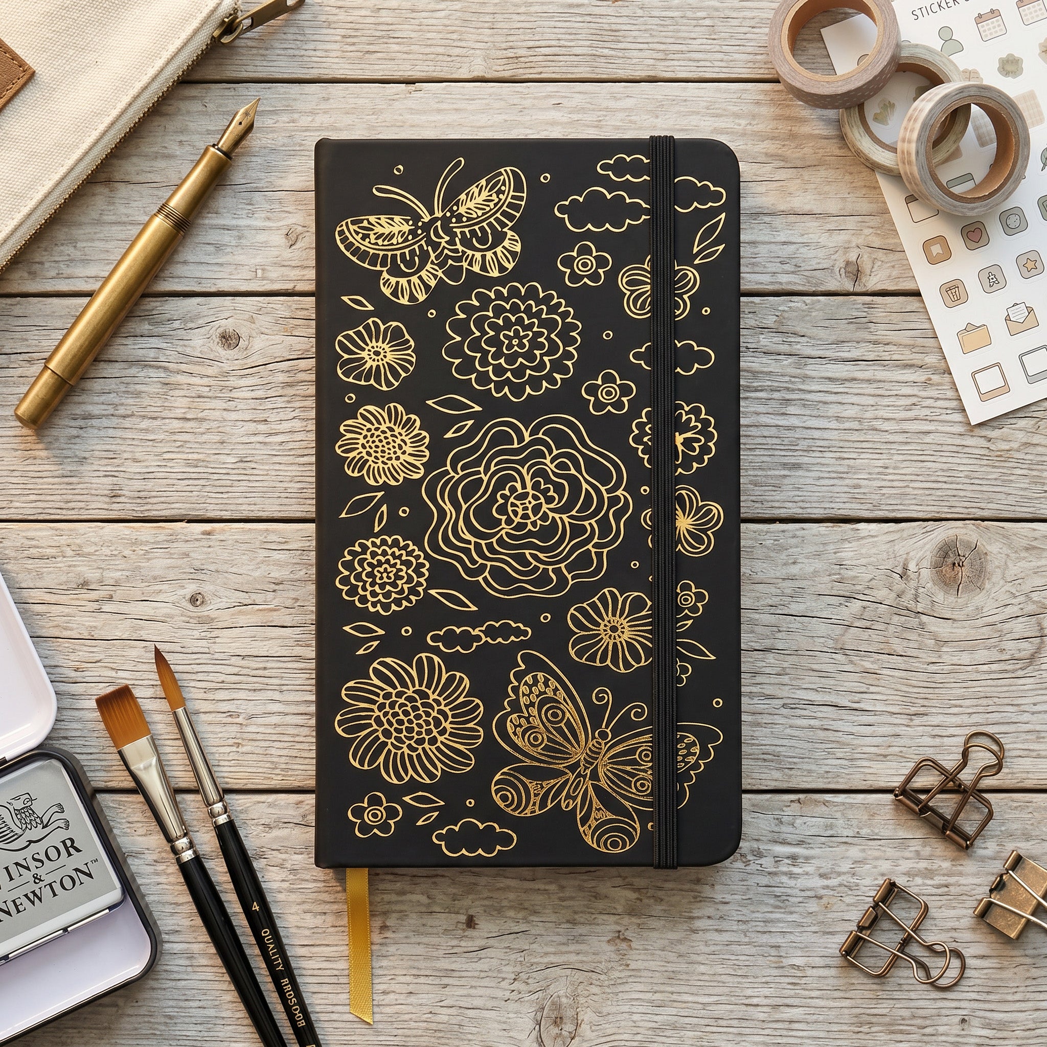 Close-up of gold butterfly and floral design on black faux PU leather notebook cover