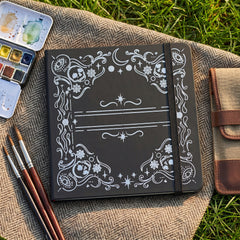 Angled view of BUKE black gothic dot grid notebook with elastic band