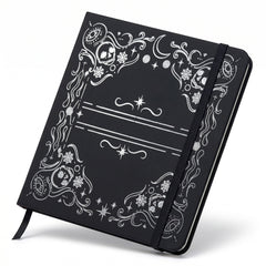 Detail of skull, moon, and spiderweb frame on black square notebook