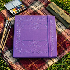 Purple dot grid notebook styled in a creative stationery flat lay